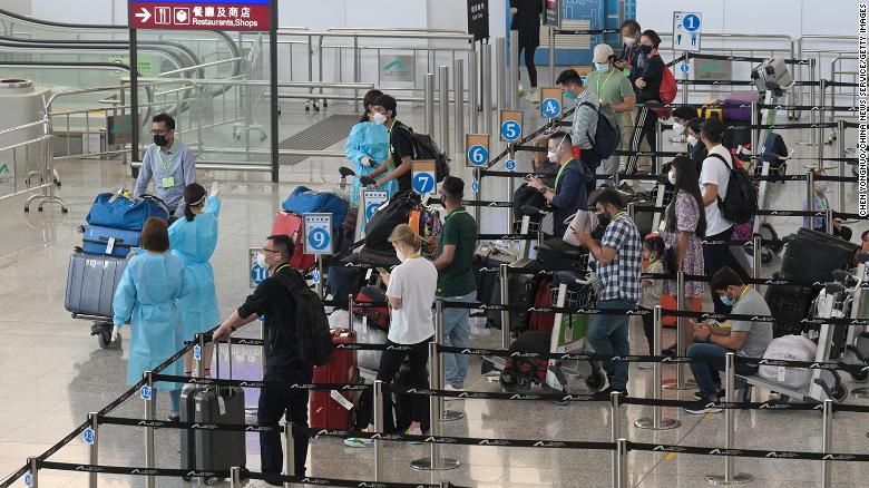 Travelers at Hong Kong International Airport wait in line for shuttle buses to their quarantine hotels in August 2022.